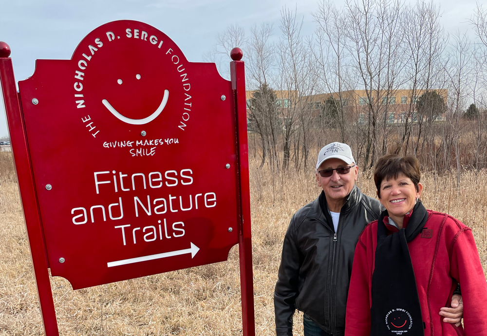 Dominic and JoAnn Sergi standing in front of Sergi Fitness and Nature Trails sign