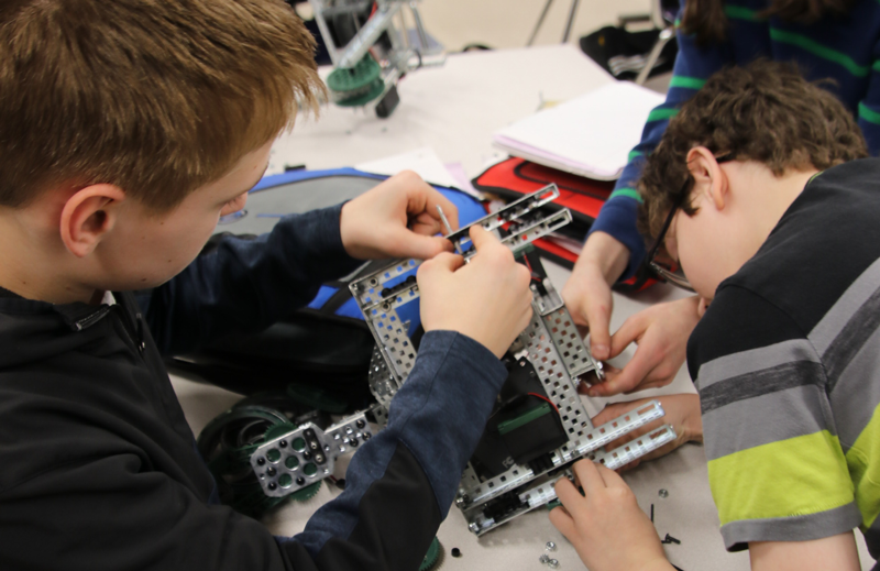 Two students building a robot