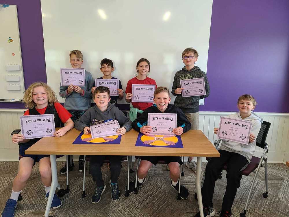 Jackson Elementary students hold certificates and smile at camera