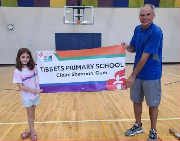 Tibbets student poses with banner and gym teacher