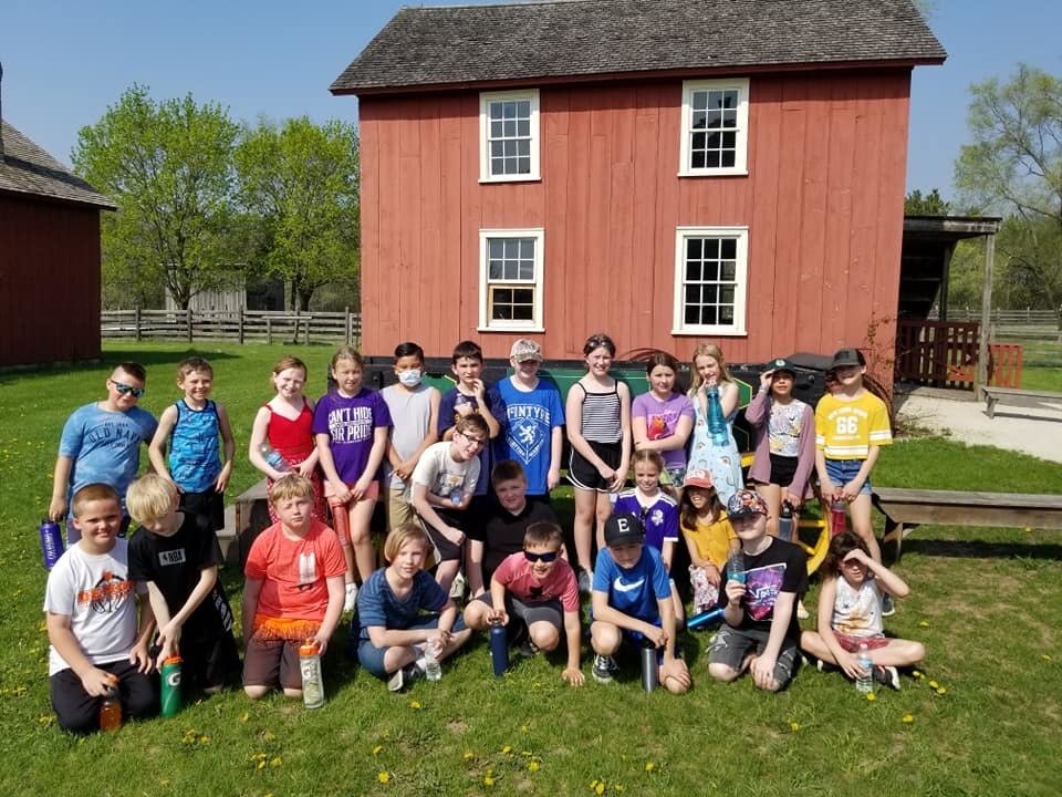 Group of students poses in the grass