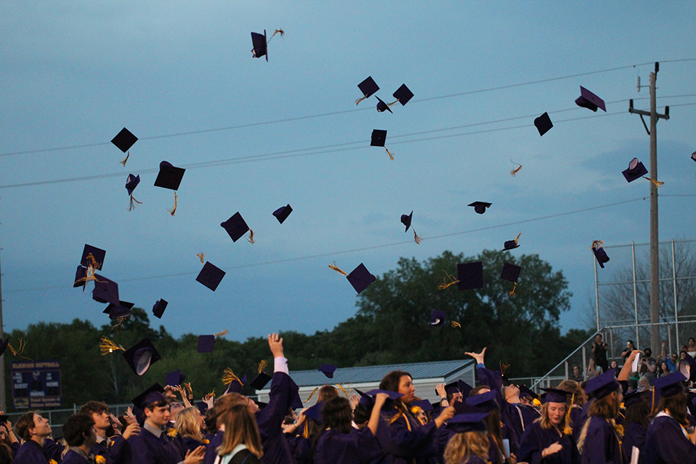 High school students throwing graduation caps in the air